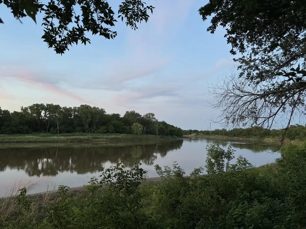 The Salt Fork River at dusk framed by lush green trees